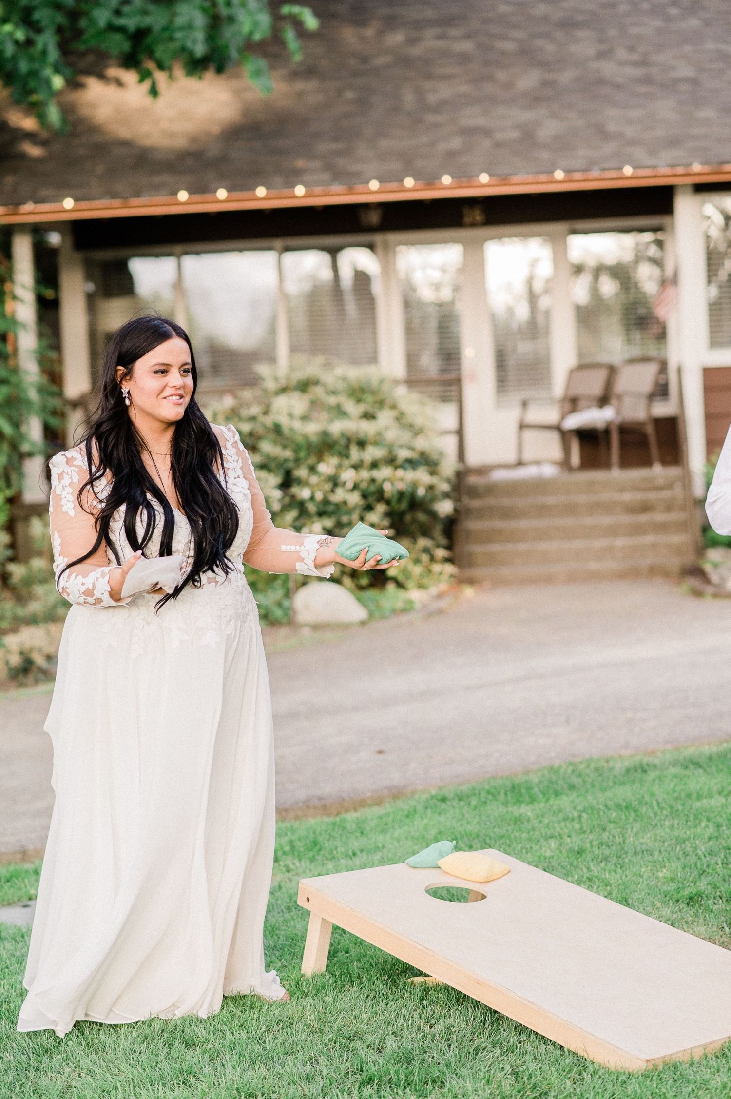 Bride playing cornhole.