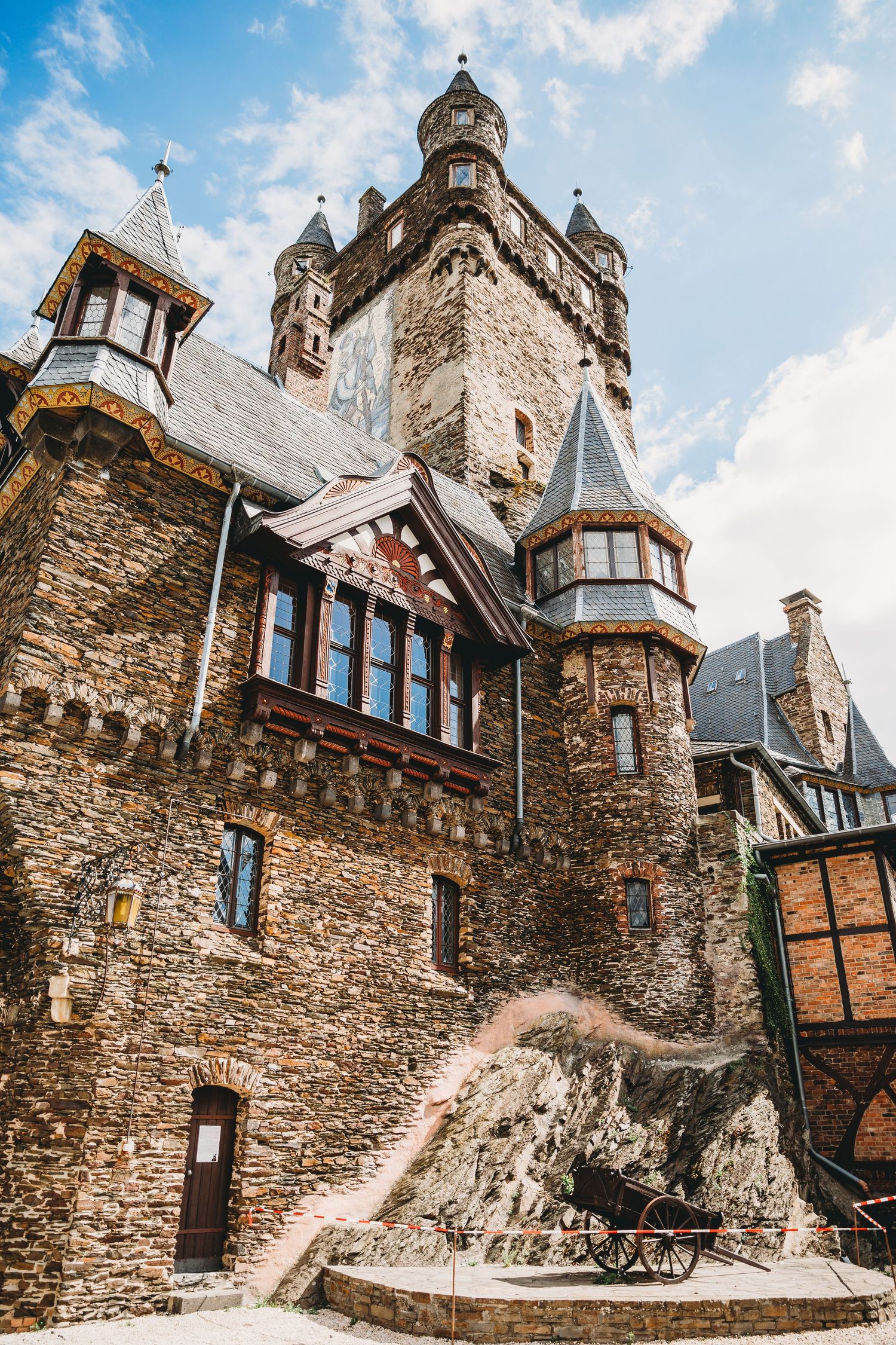 Majestic stone castle with multiple turrets, towers and steep roofs showcasing Gothic architectural style.