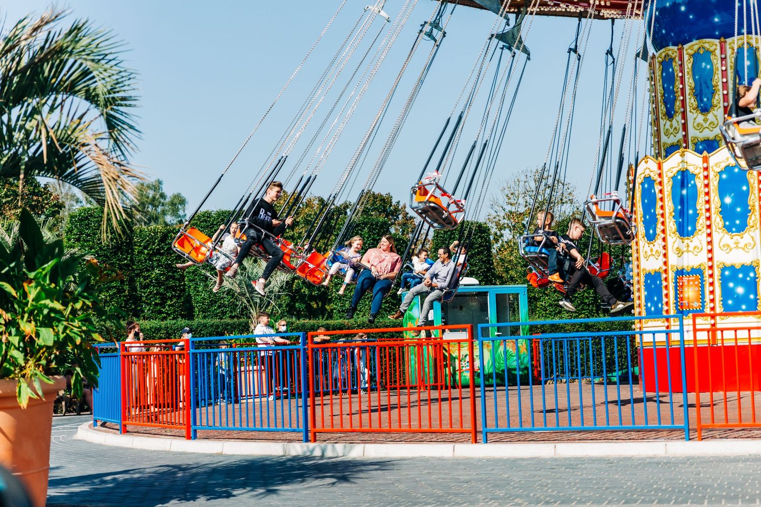 Vibrant swing carousel ride with colorful seats against blue sky at an amusement park.