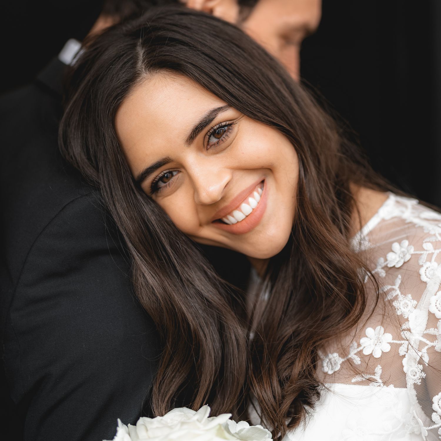 Bride embracing with groom and smiling