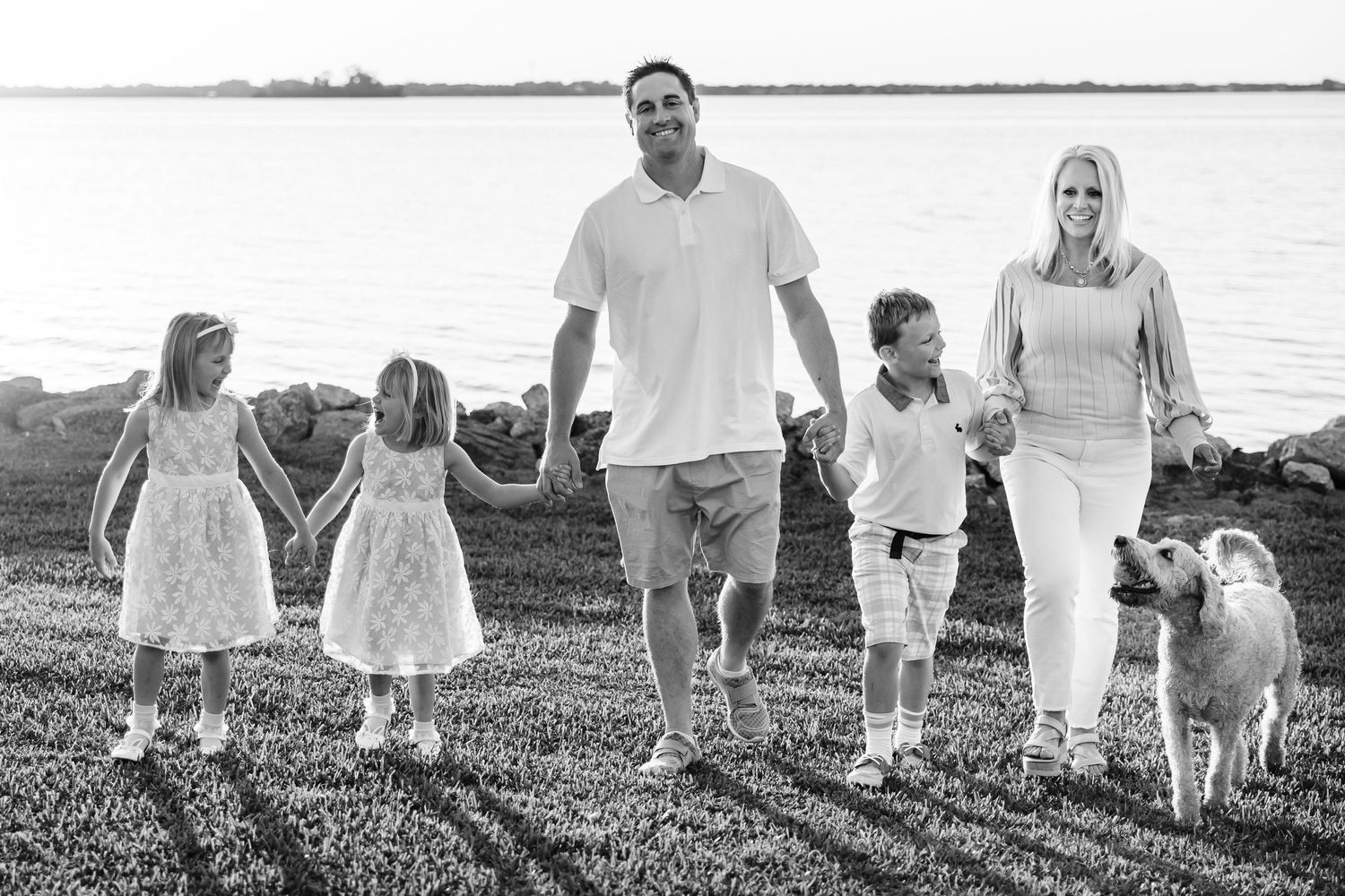 mom, dad, 3 kids and dog walking in their yard together. Space Coast FL Photographer