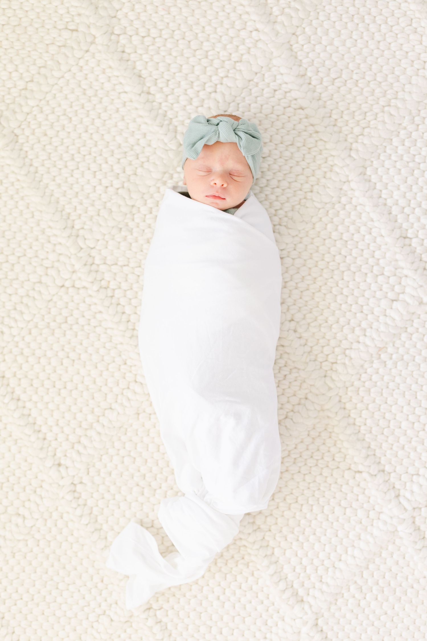 Minimal newborn portrait in white swaddle