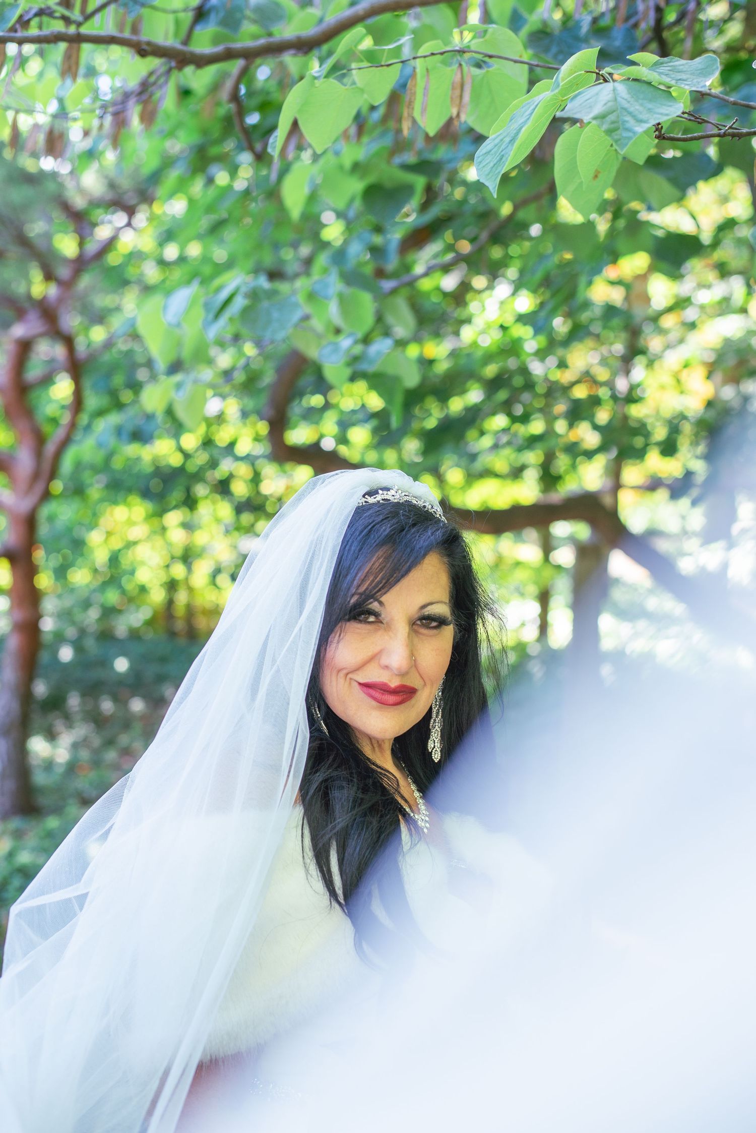 Bridal portrait with bride's vail blowing in the wind towards the camera.