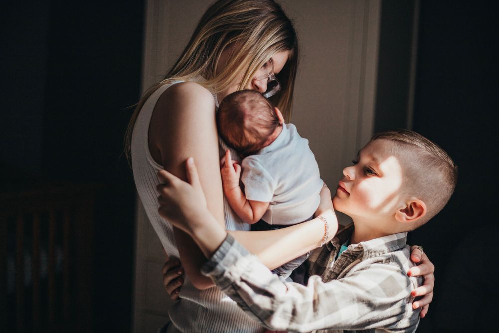 Intimate indoor family moment in natural window light.