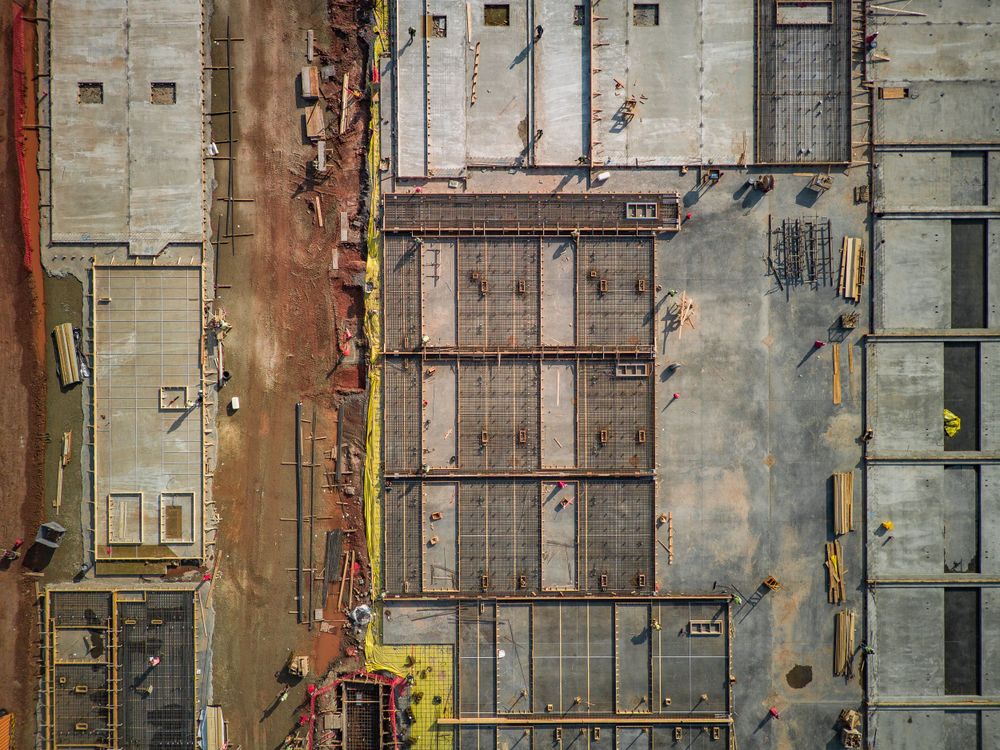 Top-down view of concrete floor sections and construction framework in progress.