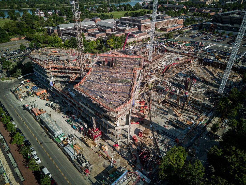 Aerial view of a large construction site with multiple cranes and concrete structures in an urban setting.