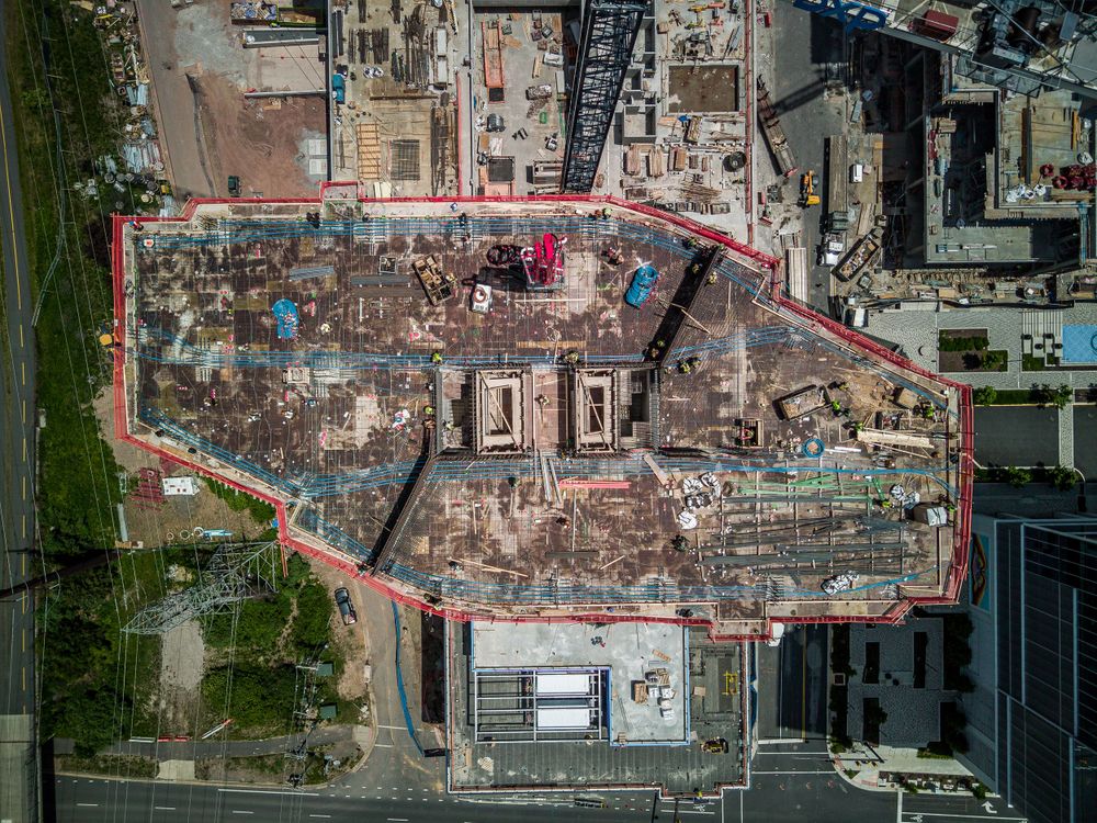 Aerial view of demolition site with red boundary line marking the construction zone.