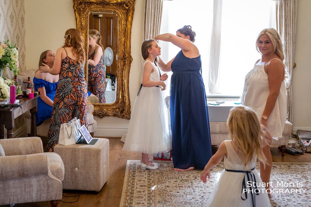 Bridesmaid does a flower girls hair at west tower Aughton. Ormskirk wedding venue. Country house wedding photography.