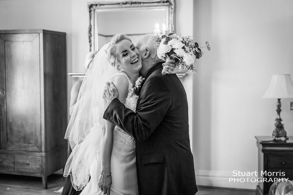 Bride gets a hug from her grandad after seeing her in her wedding dress for the first time. West tower wedding venue.