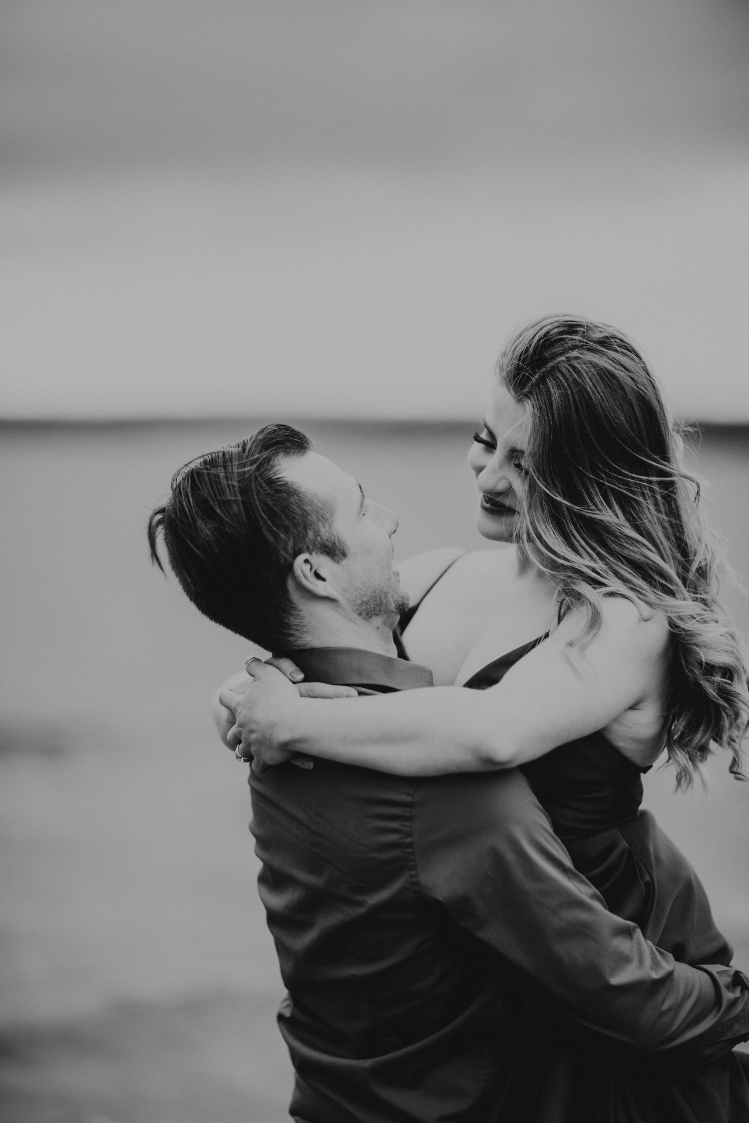 Engagement session on the beach, couple embracing each other