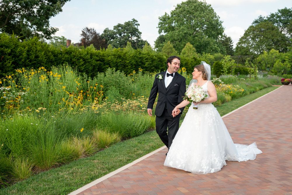 Wedding portraits captured along garden pathway with natural greenery.