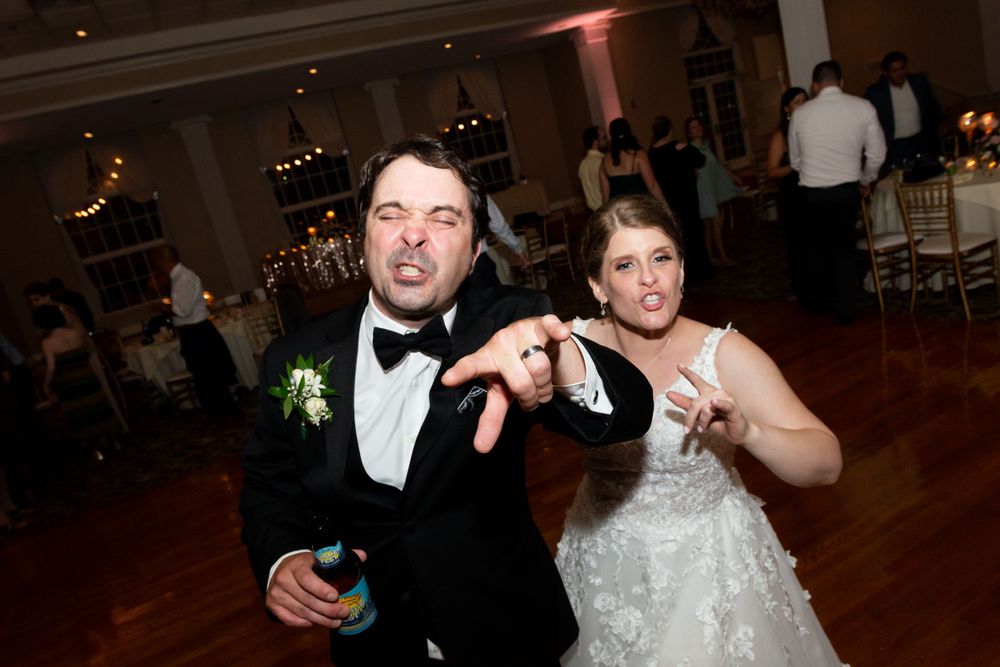 Wedding party members celebrating with drinks and candid moments on the dance floor.