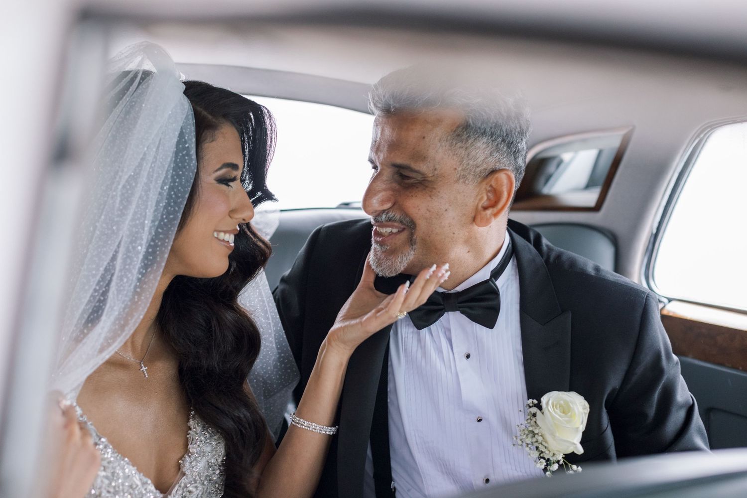Candid moment of newlyweds sharing a tender moment in wedding car.