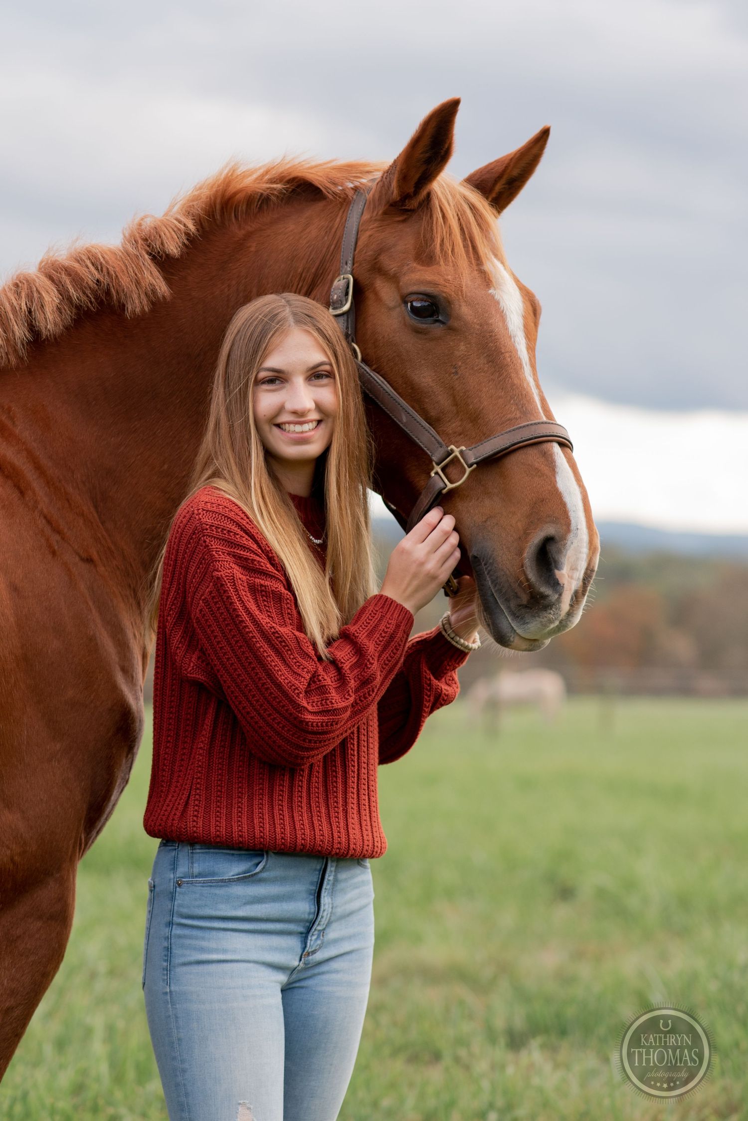 A chestnut horse and companion in red sweater share a tender moment in an autumn field.