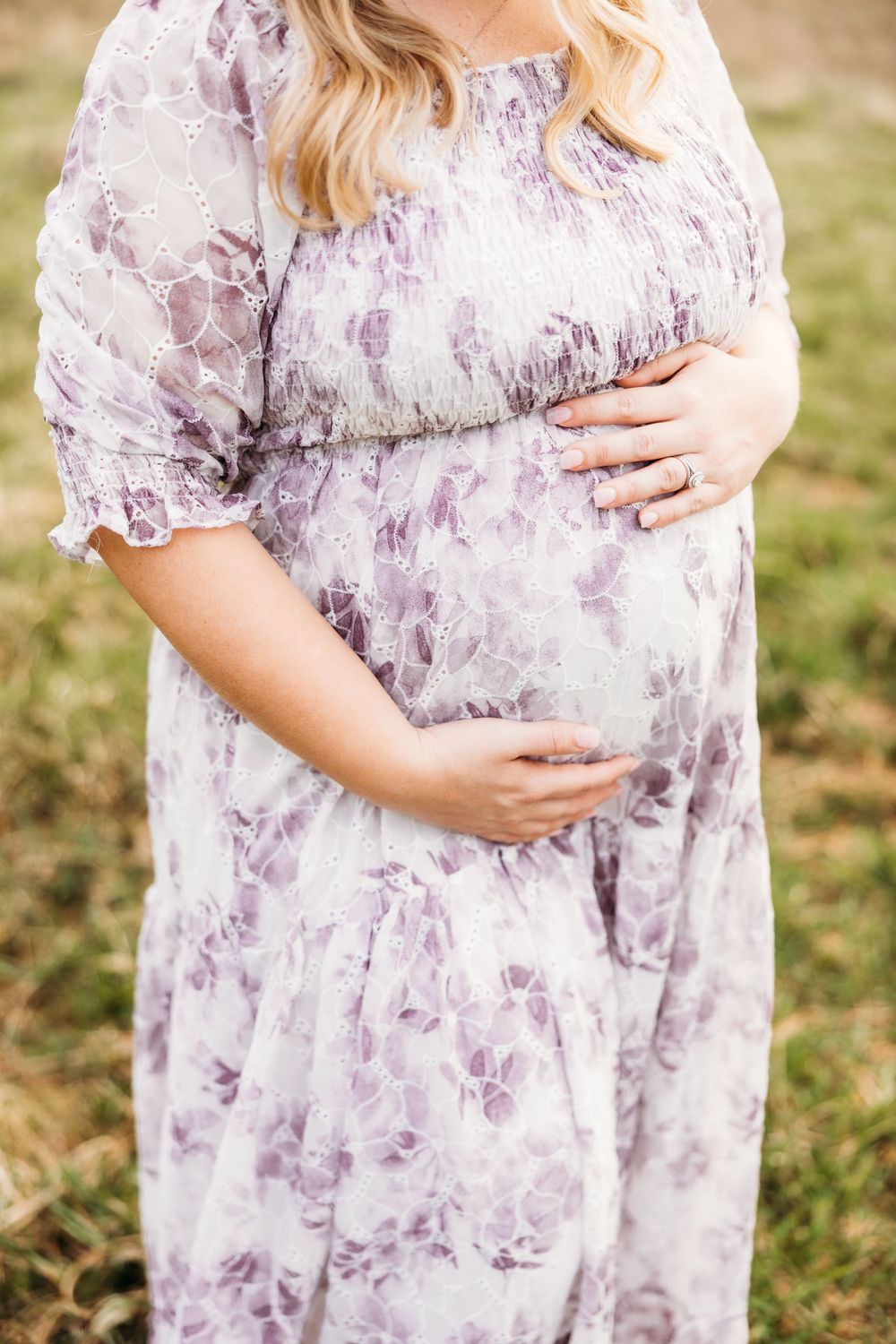 Close up of purple floral maternity dress showing pregnant belly.