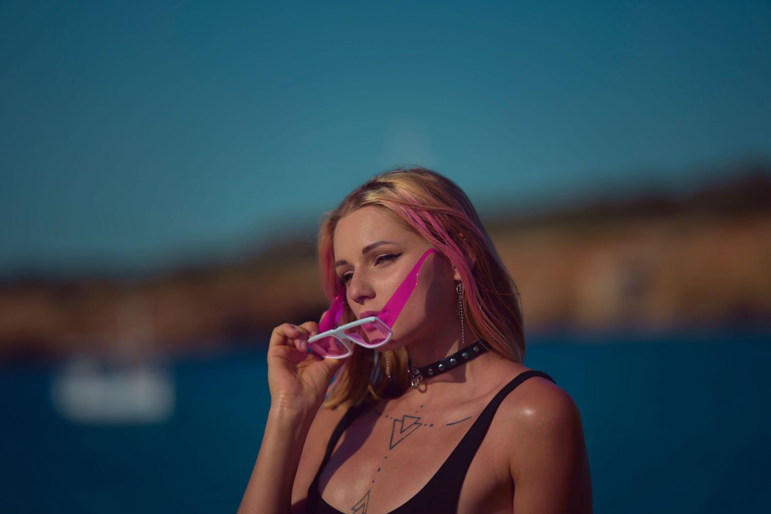 Person with pink lighting enjoying a summer day by the ocean.