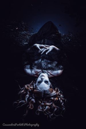 Artistic dark portrait with dramatic shadows and flowing hair.