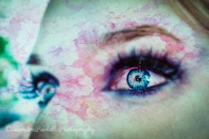 Extreme close-up artistic photograph of eyes with teal and pink tones.