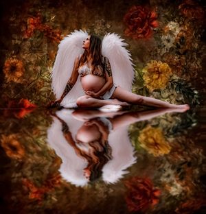 Artistic maternity photo with angel wings reflected in autumn-colored water.