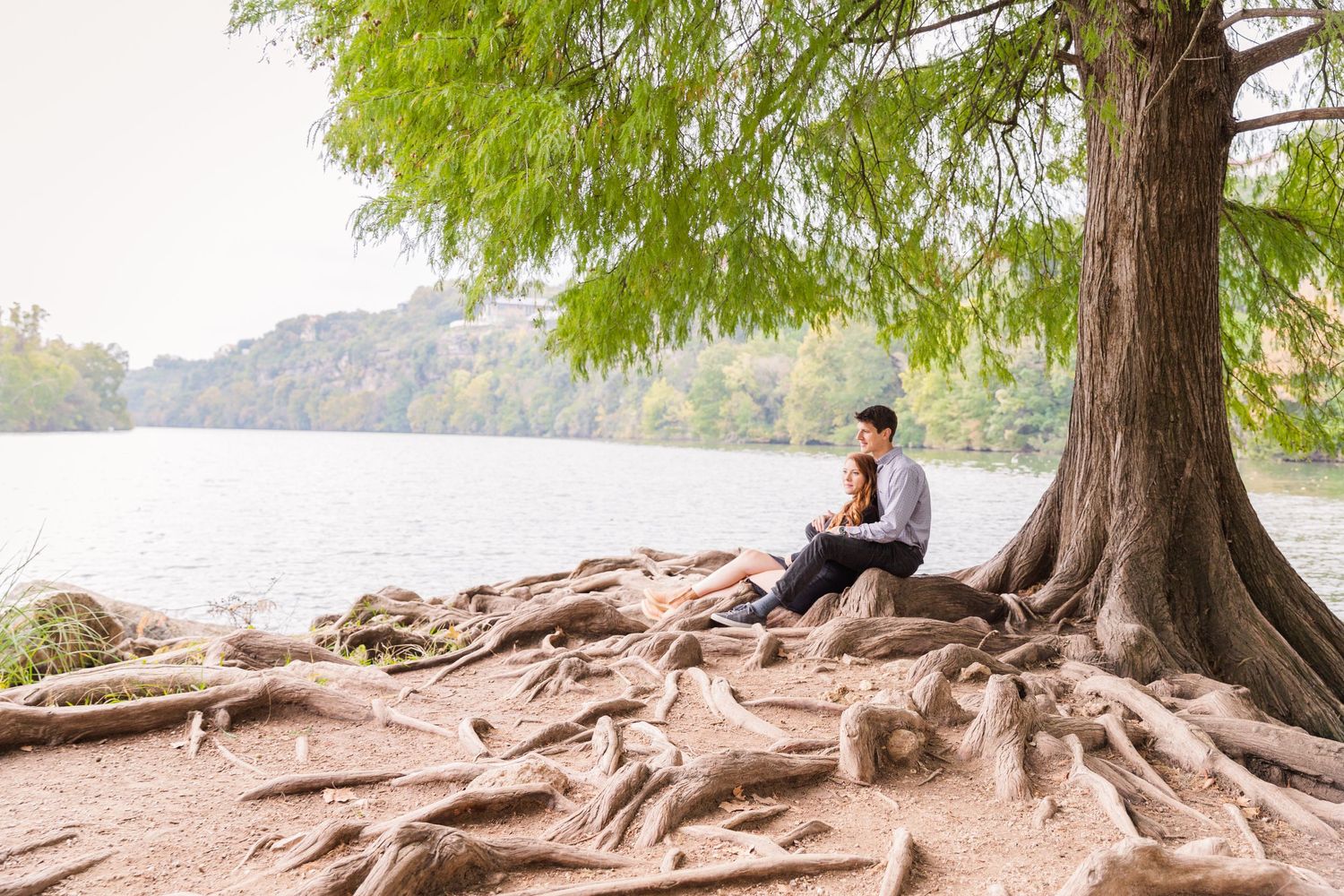 couple sitting under tree on Red Bud Isle in Austin, TX