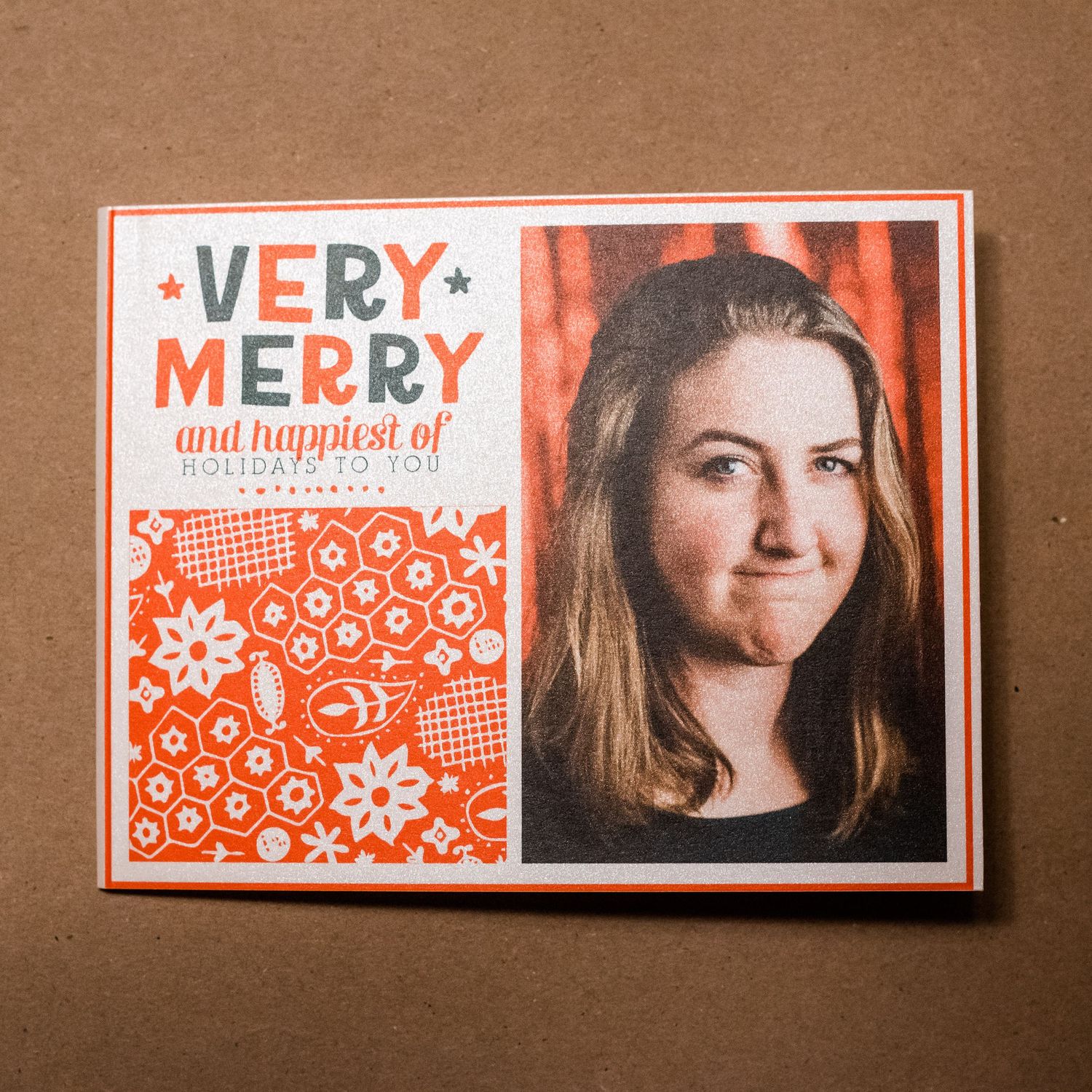 Red and white holiday greeting card featuring a portrait photo and festive snowflake pattern design.