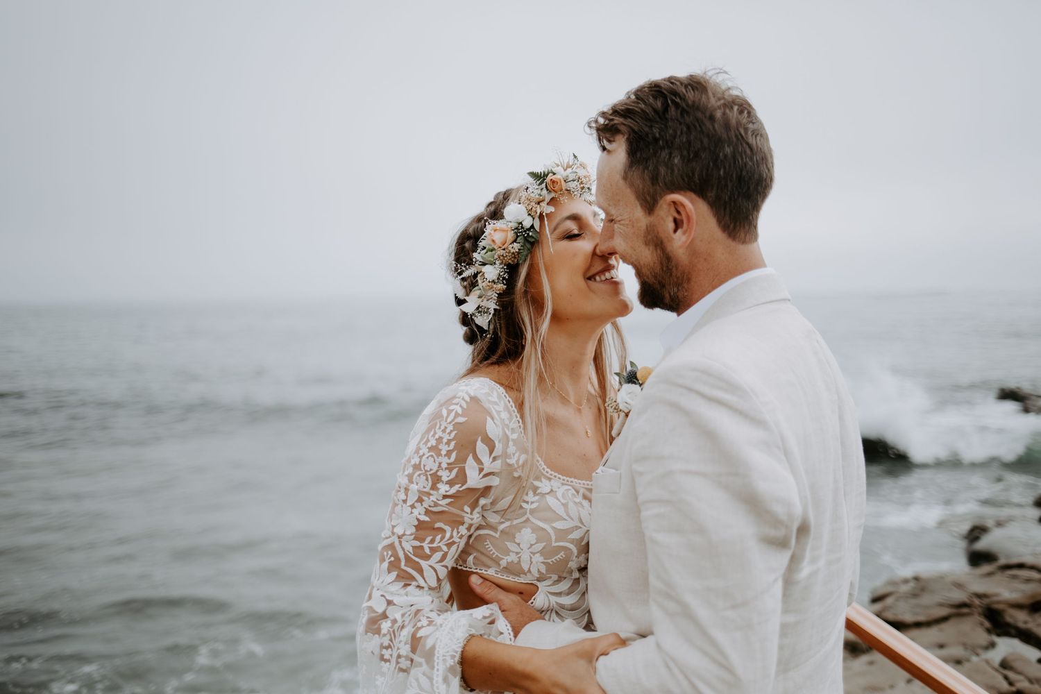 A romantic oceanside moment captured with lace dress details and coastal scenery in the background.