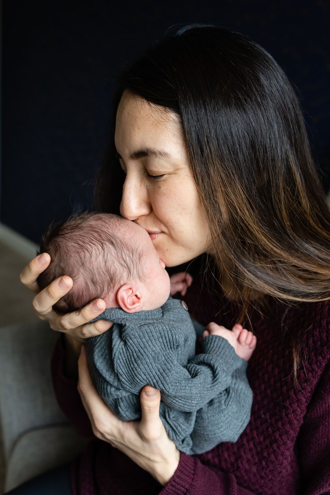 Bellevue newborn photographer capturing mother kissing newborn baby on the head.