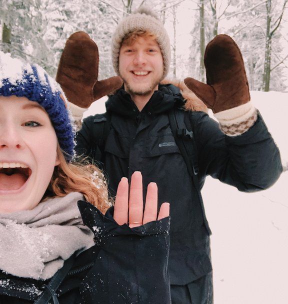 magda and adam stood, covered in snow with their hands up