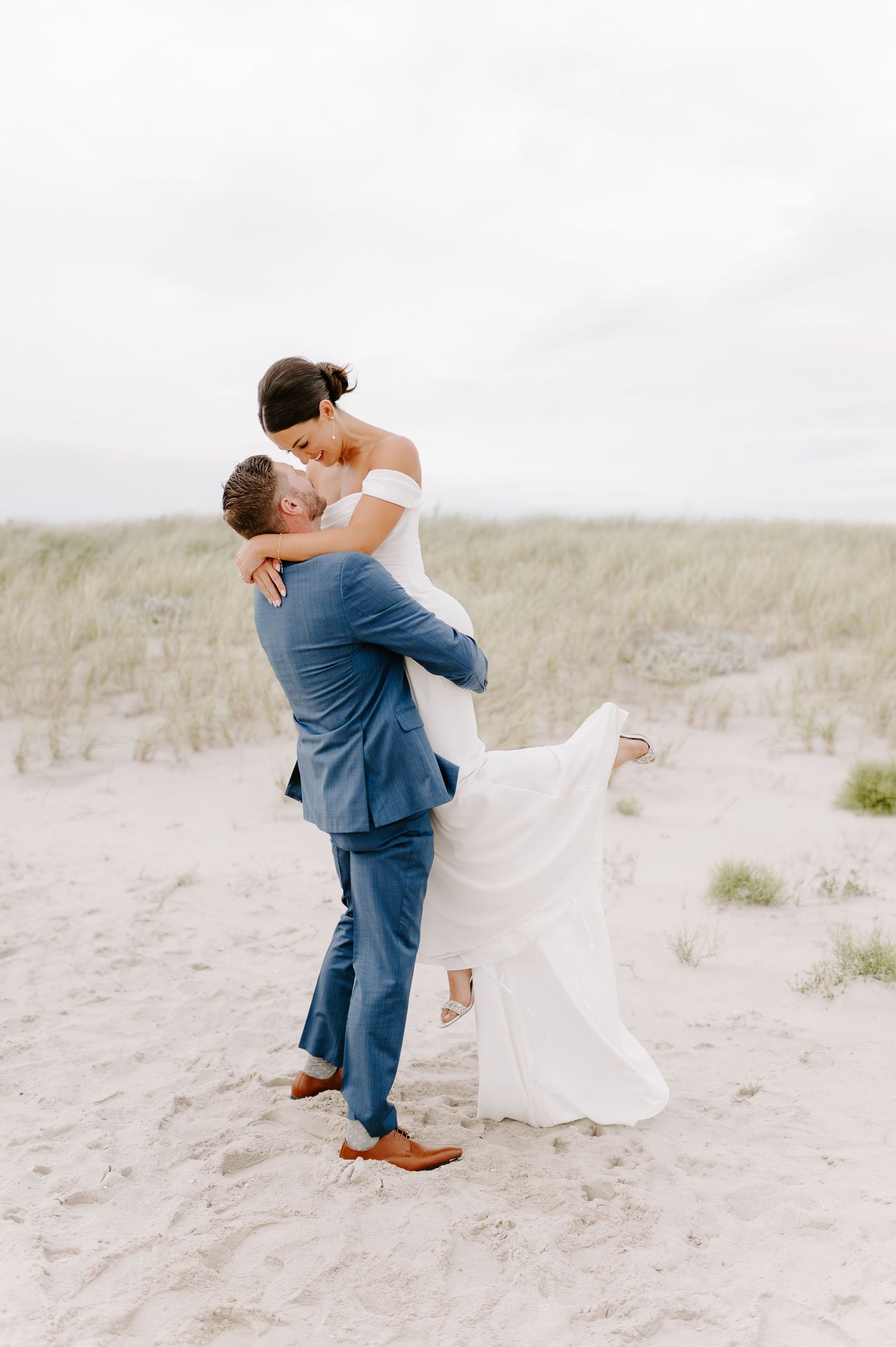 Romantic beach wedding portraits with couple dancing in sand.