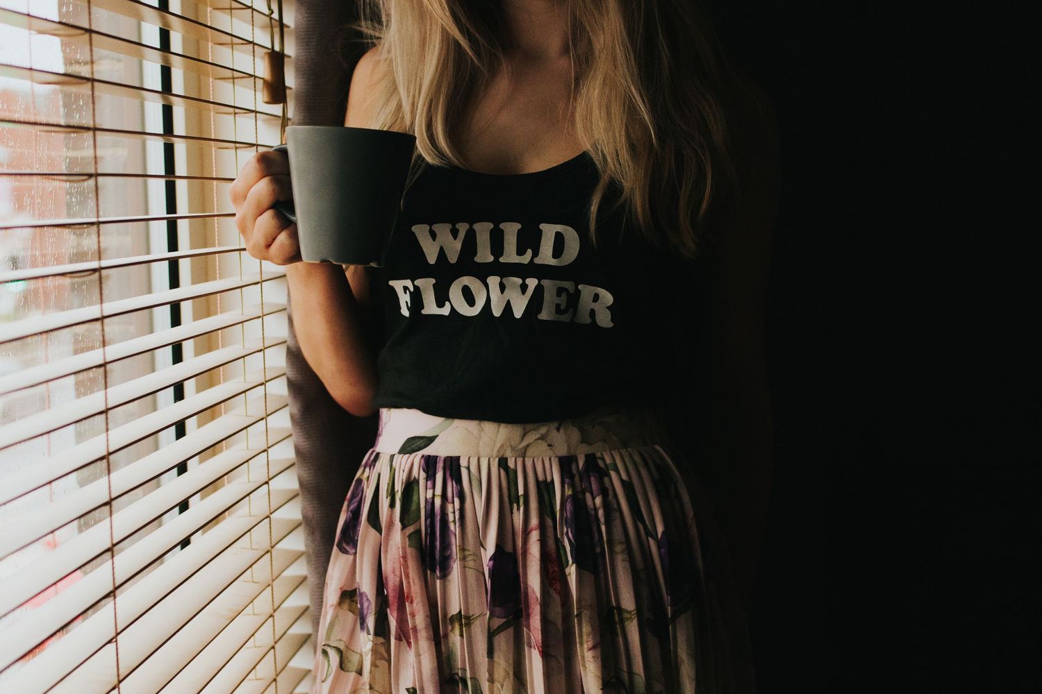 photo of Chelle Lundy stood in window light holding a coffee boho style