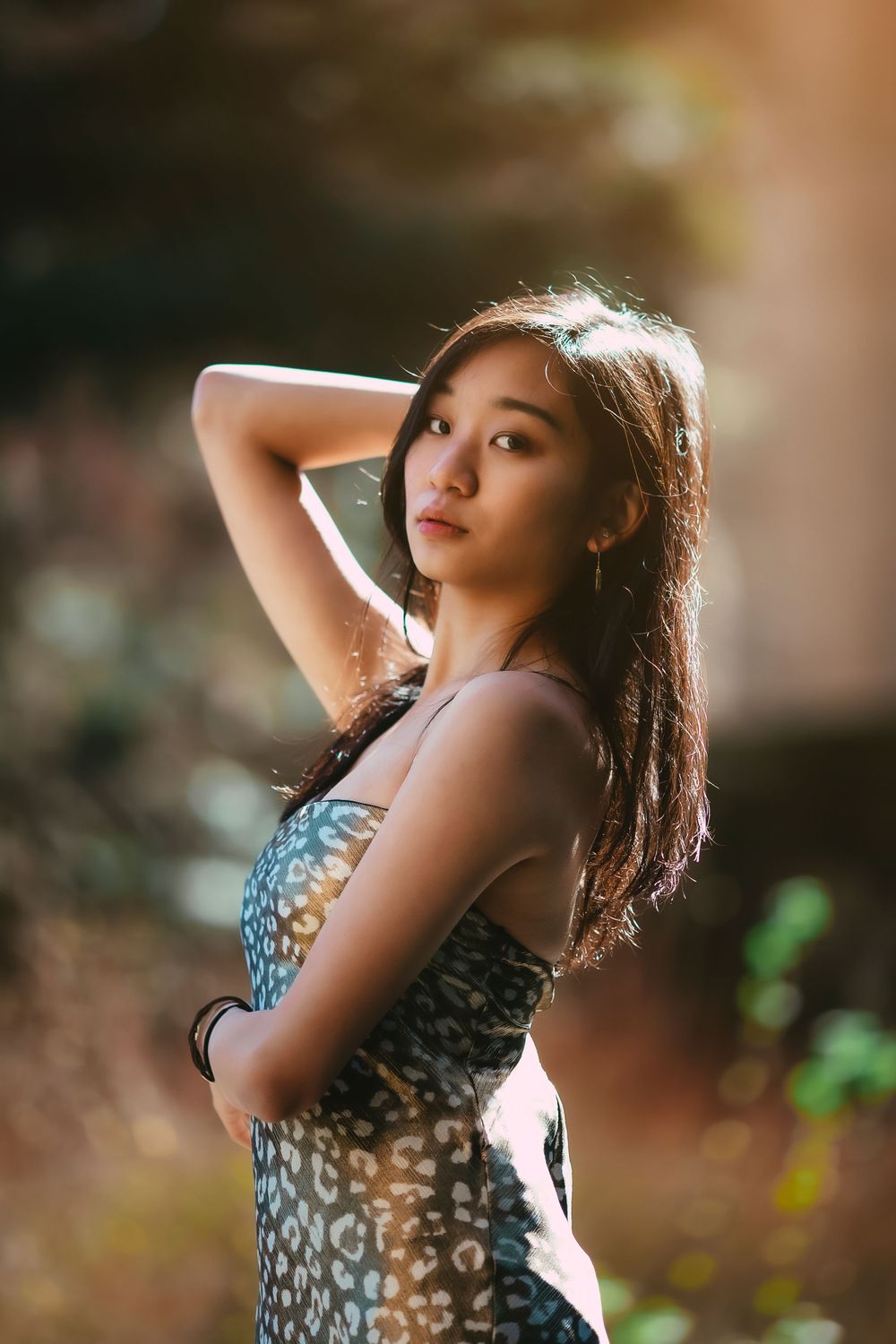 Artistic portrait of a woman with backlit hair in natural lighting.