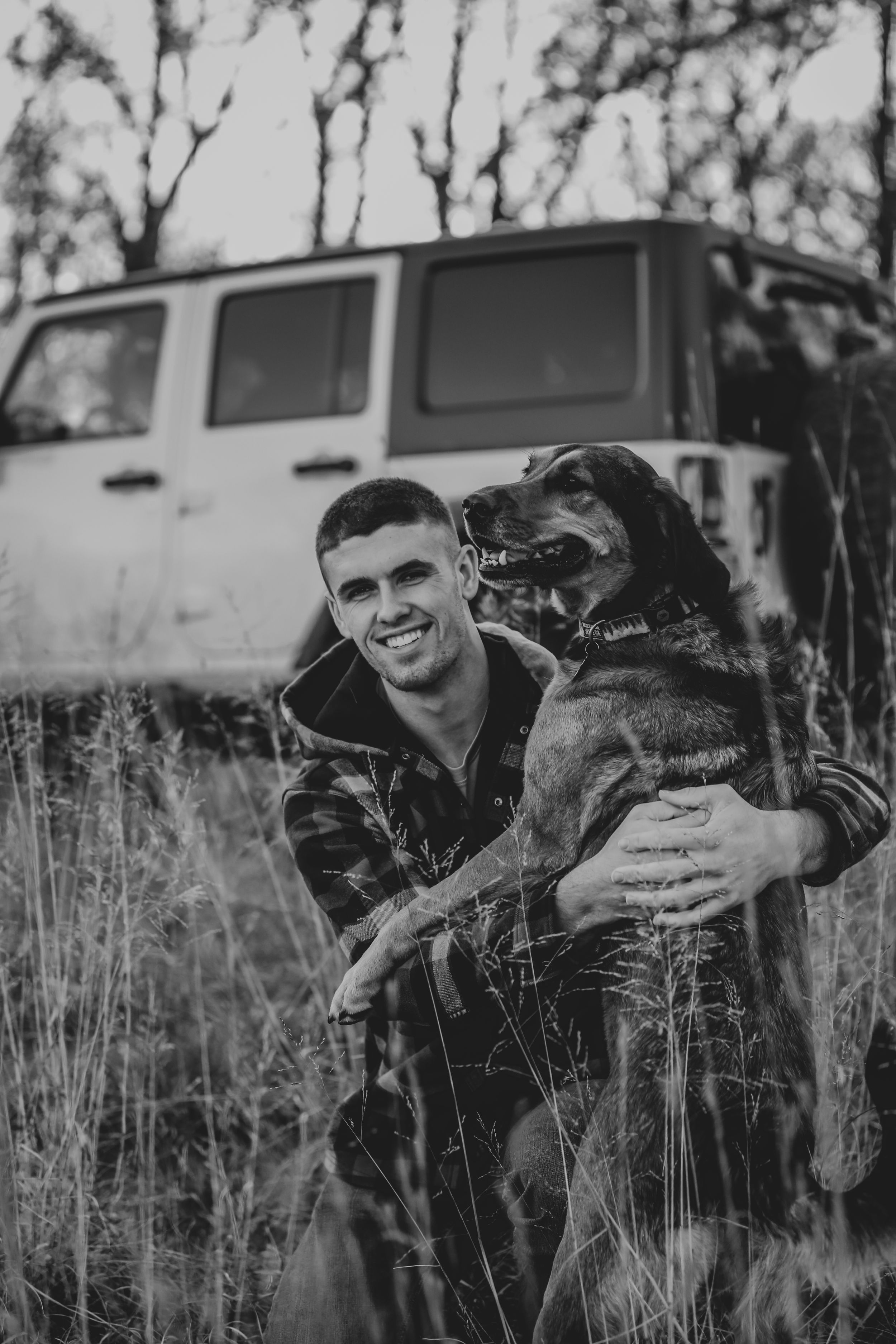 boy and dog in front of jeep