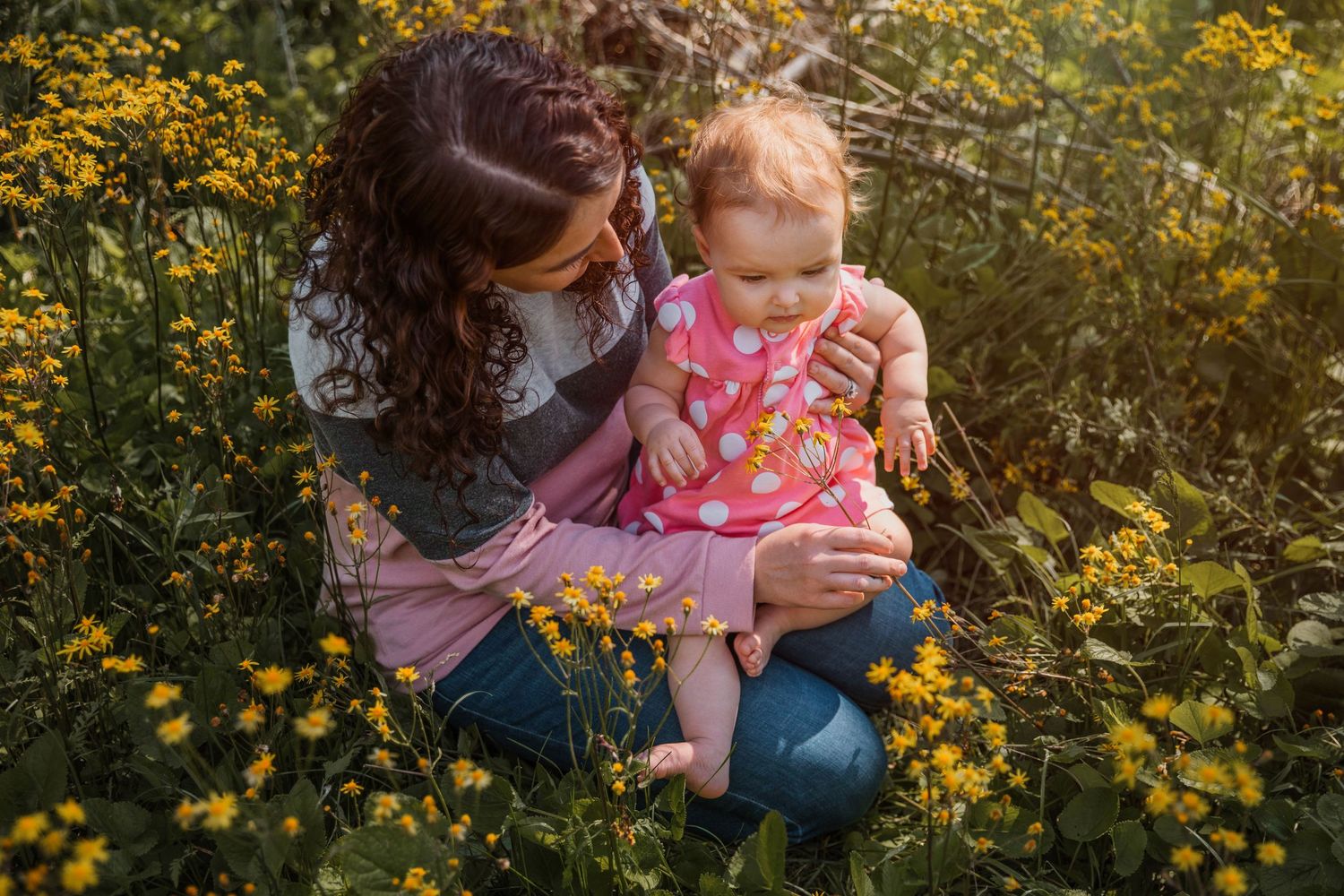 A tender moment between parent and child among yellow wildflowers in a meadow.