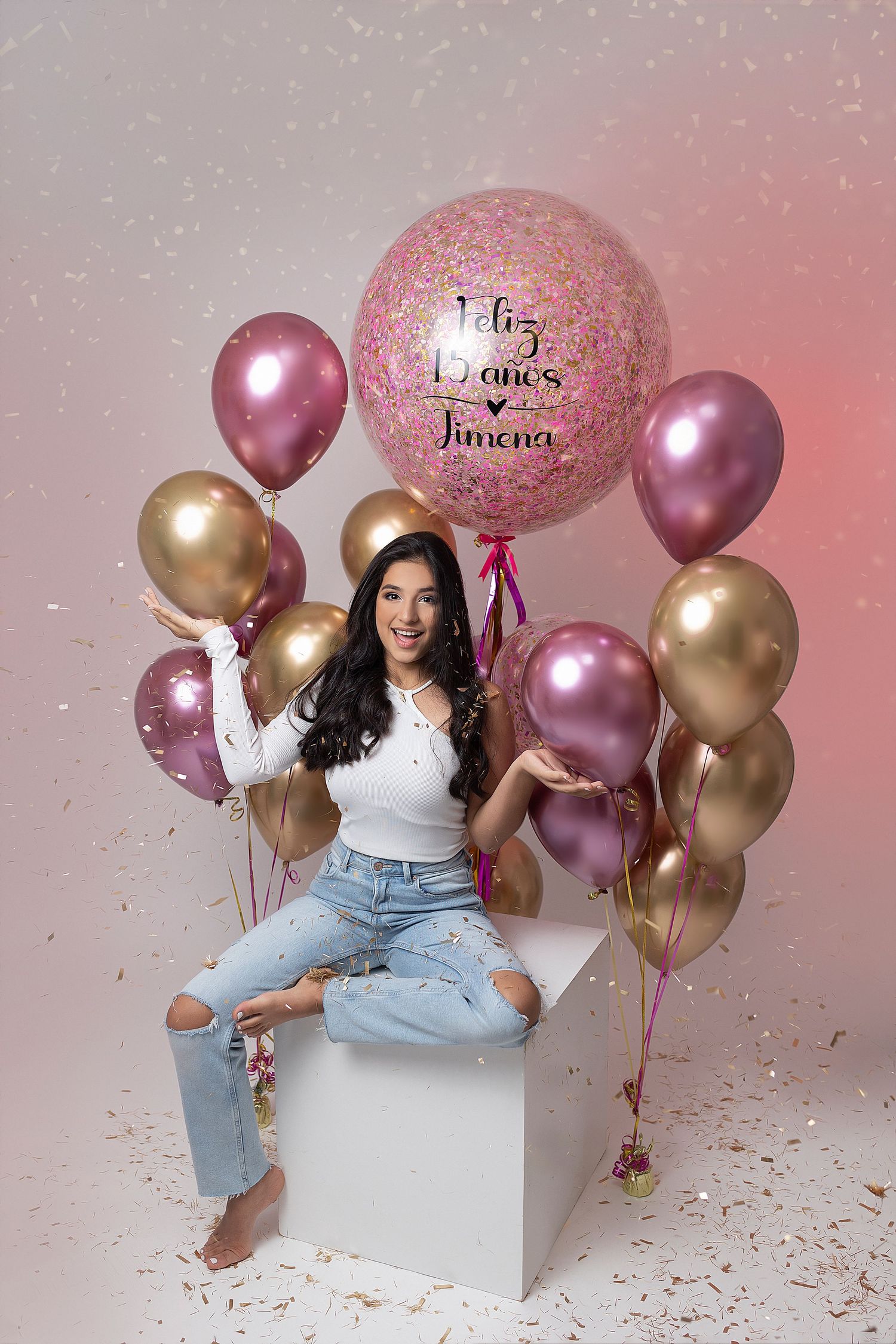 Birthday celebration photoshoot with pink and gold balloons and glitter confetti.