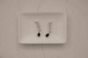 Wedding accessories and jewelry displayed on white ceramic trays.