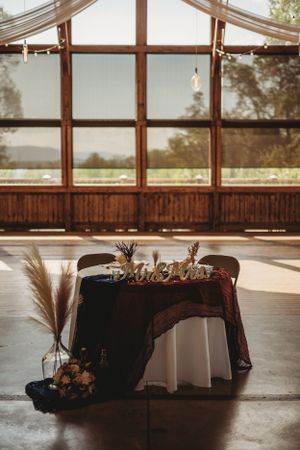 Wedding reception venue interior with round tables and large windows letting in natural light.