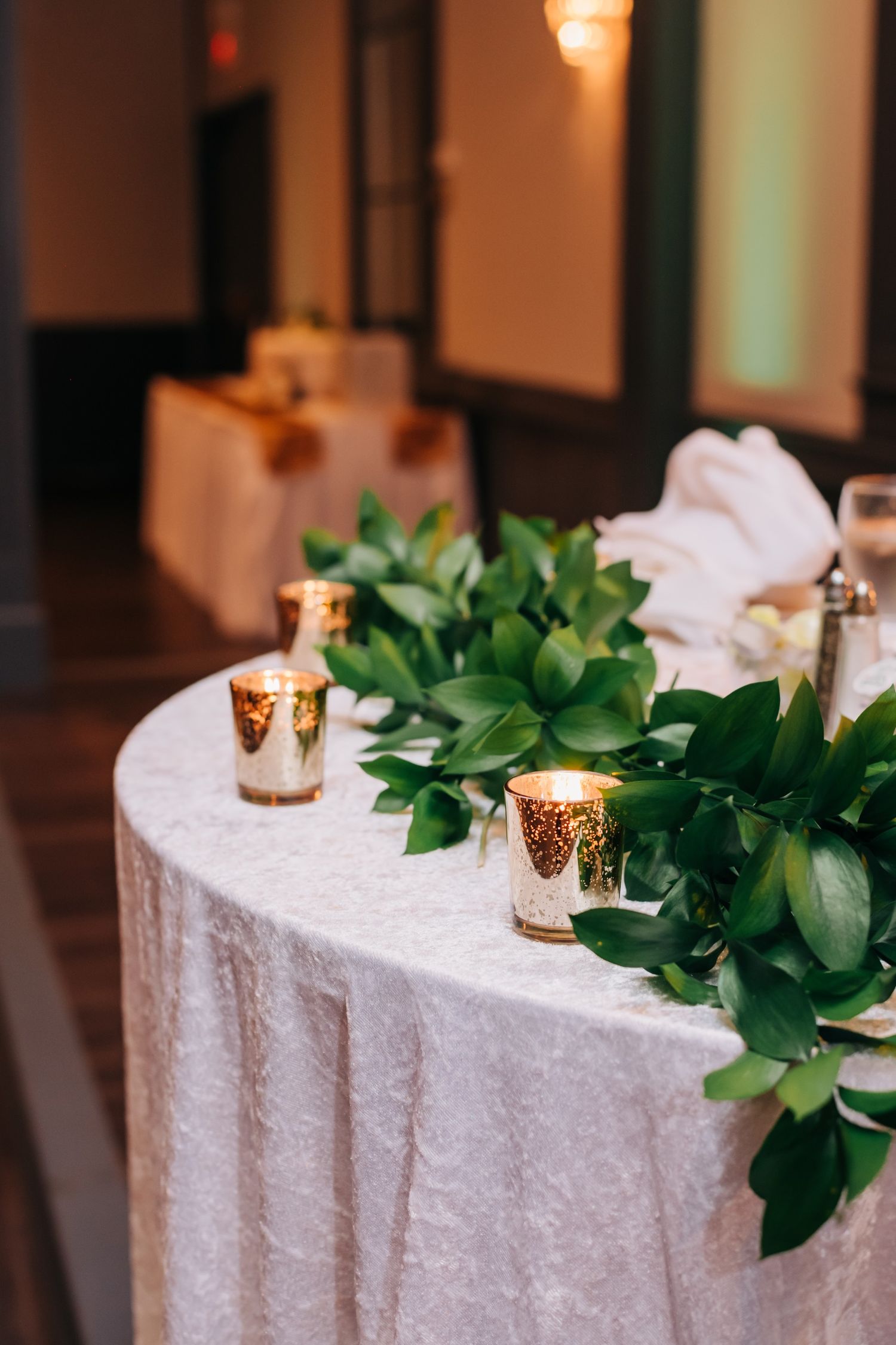 gold candles and greenery at wedding reception