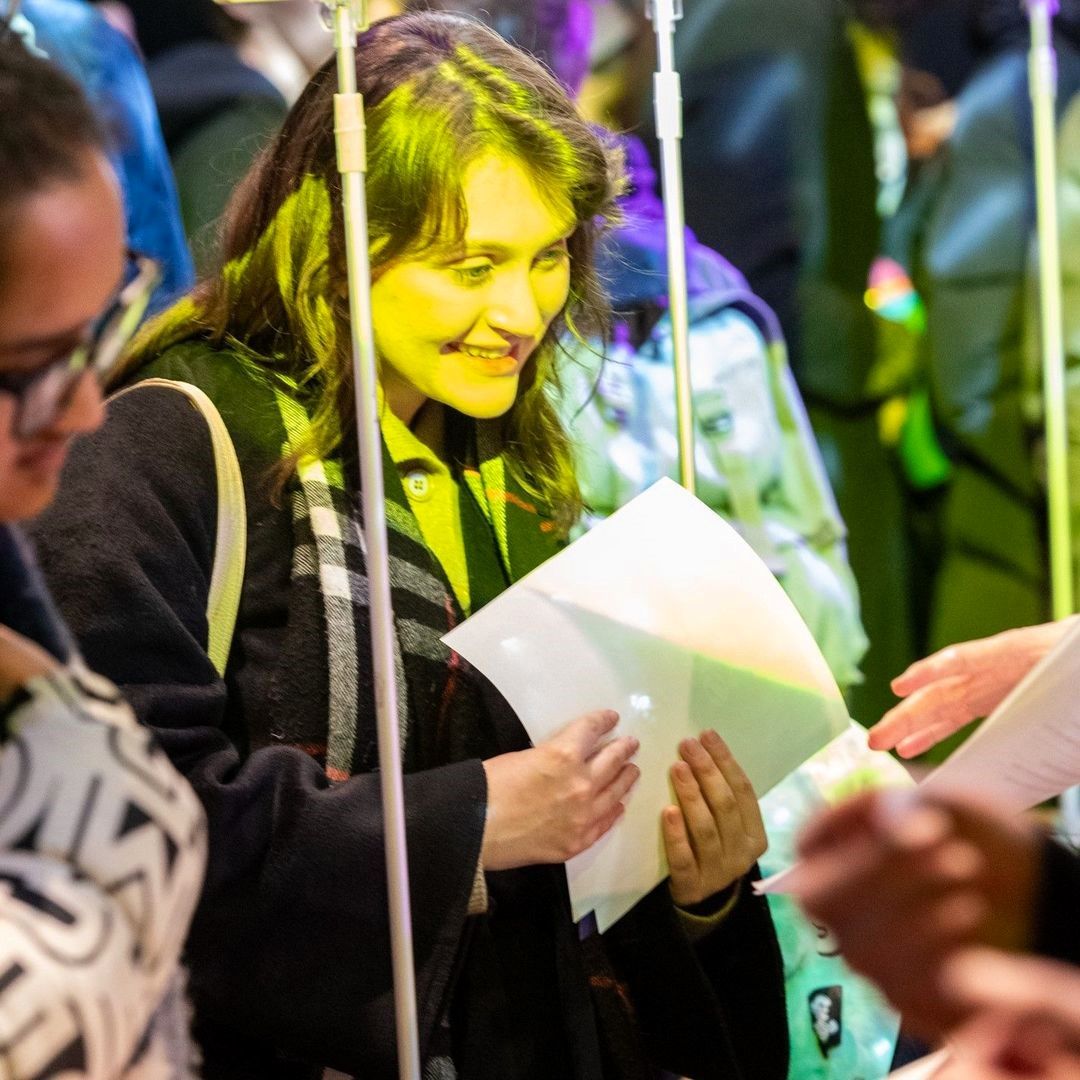 Students participating in event activities under colorful lighting.