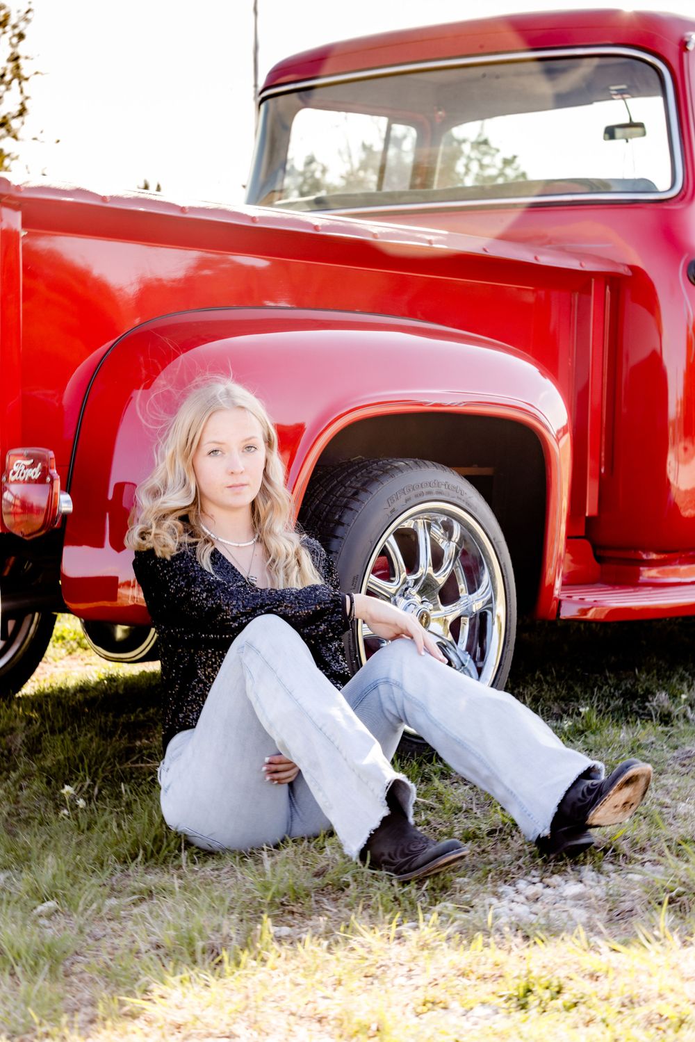 Classic red vintage pickup truck with custom wheels in outdoor setting.