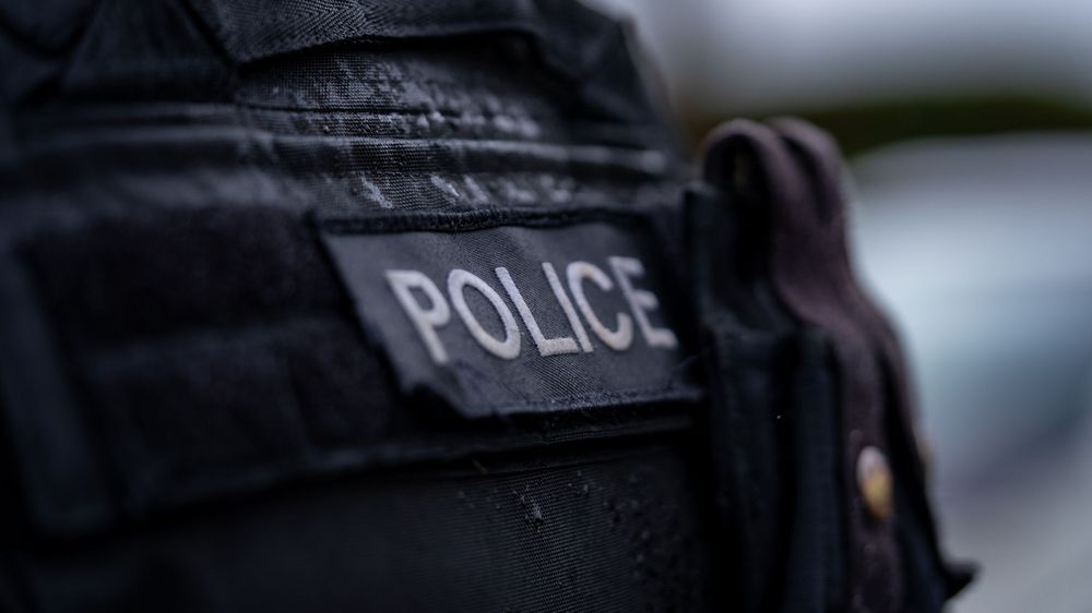 Close-up shot of a police patch on a dark uniform.