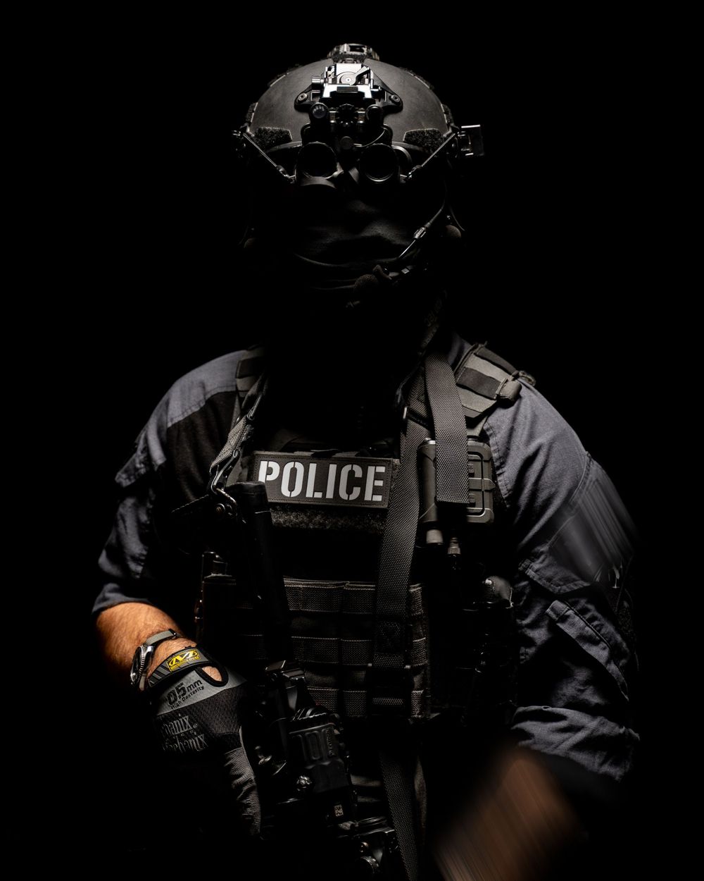 Dramatic low-key portrait of tactical police officer with night vision equipment.