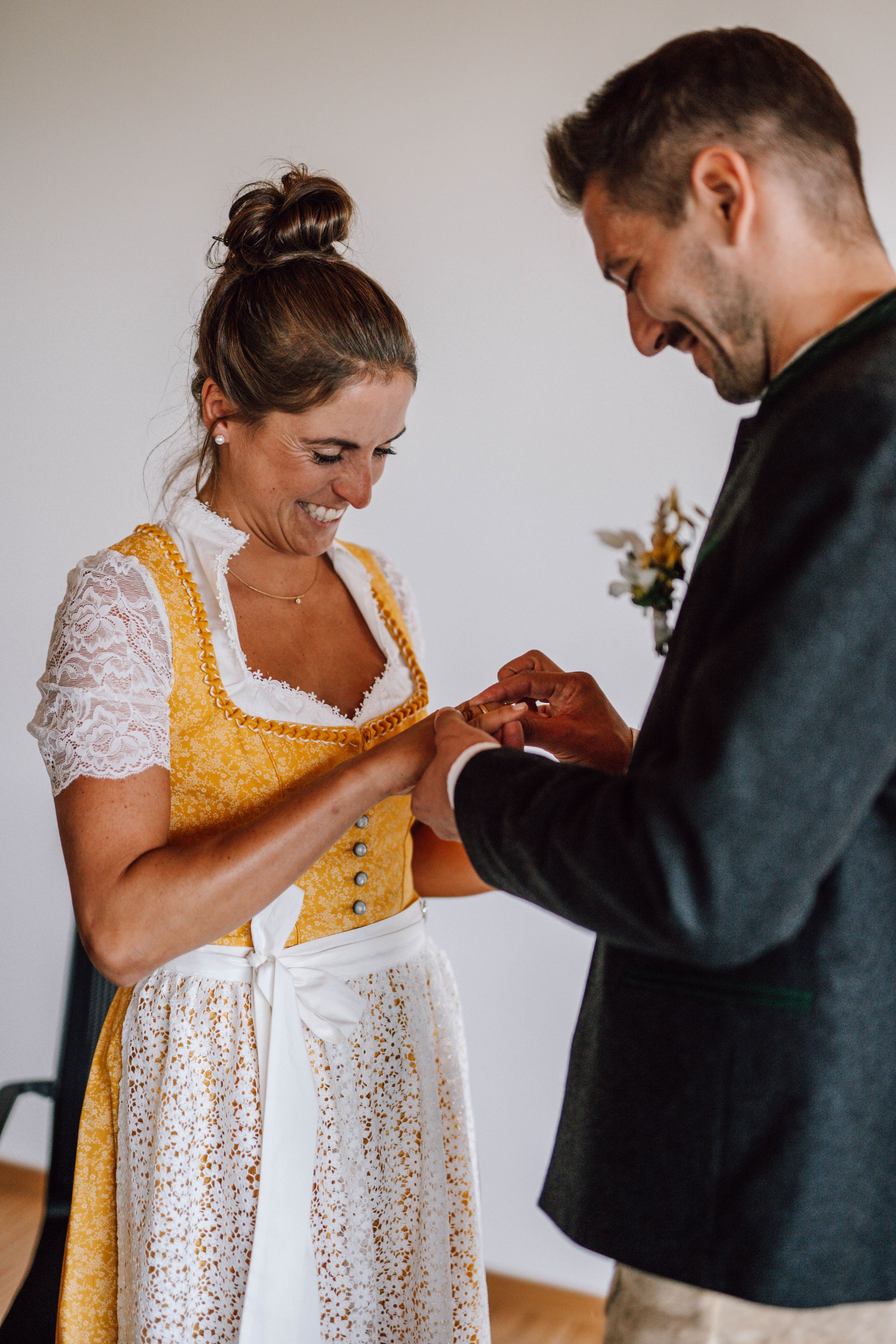 A couple in traditional Bavarian wedding attire sharing a tender moment indoors.