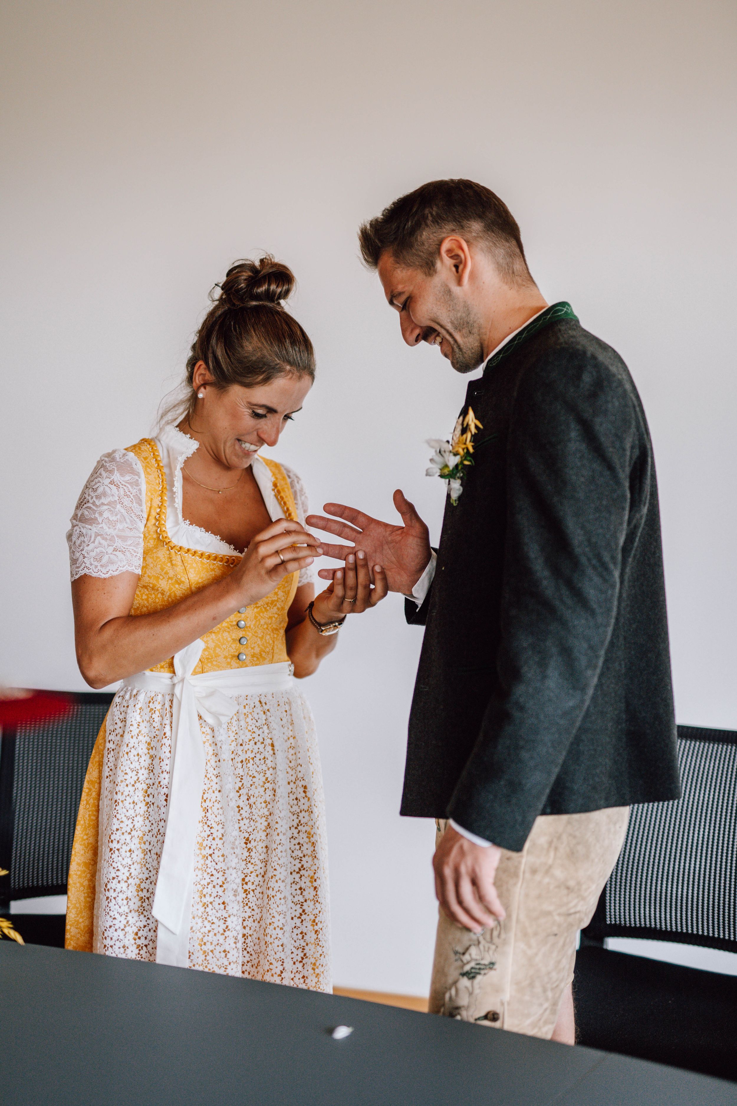 A couple in traditional dress sharing an intimate moment while exchanging rings.