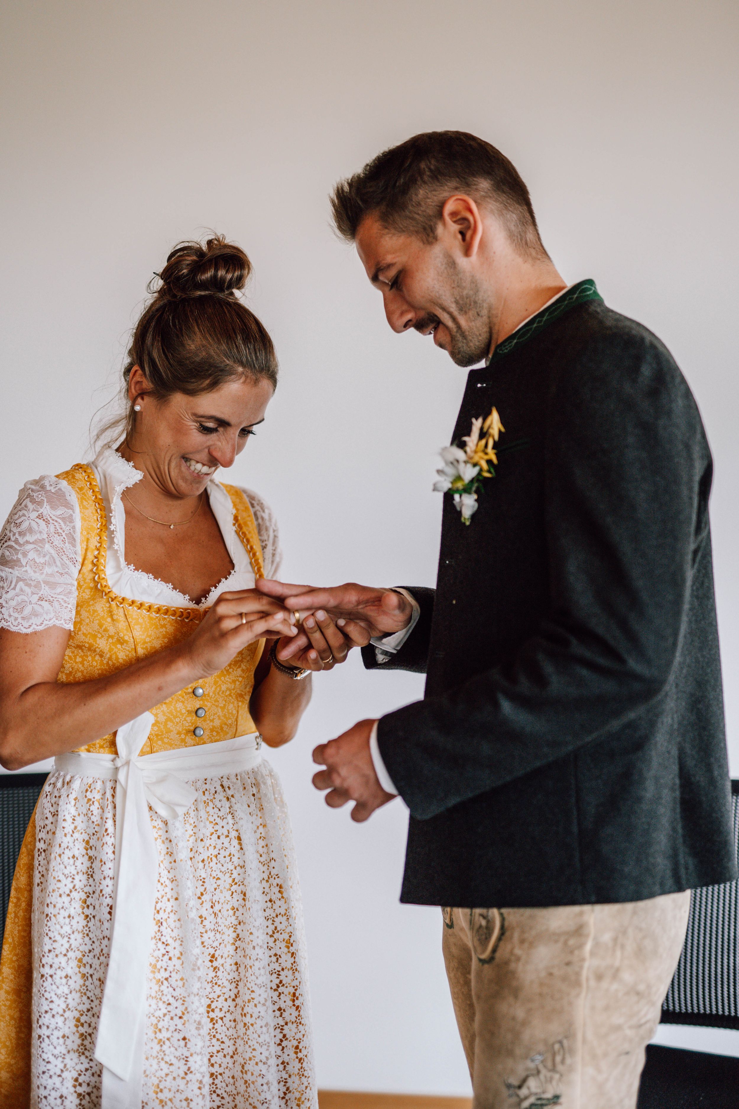 A couple in traditional German dress sharing an emotional moment while exchanging rings.