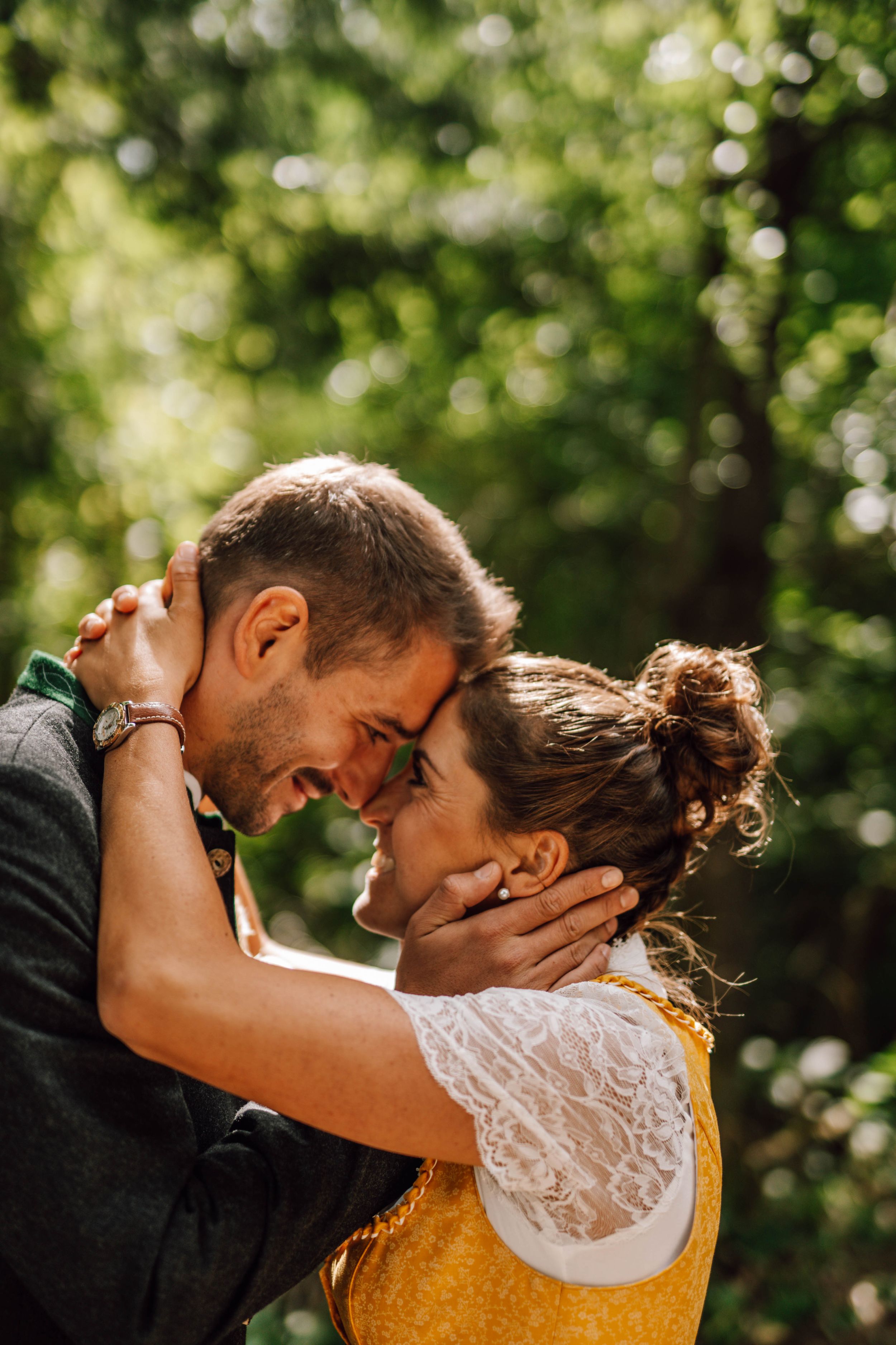 A romantic wedding moment captured in a sun-drenched garden setting with soft bokeh background.