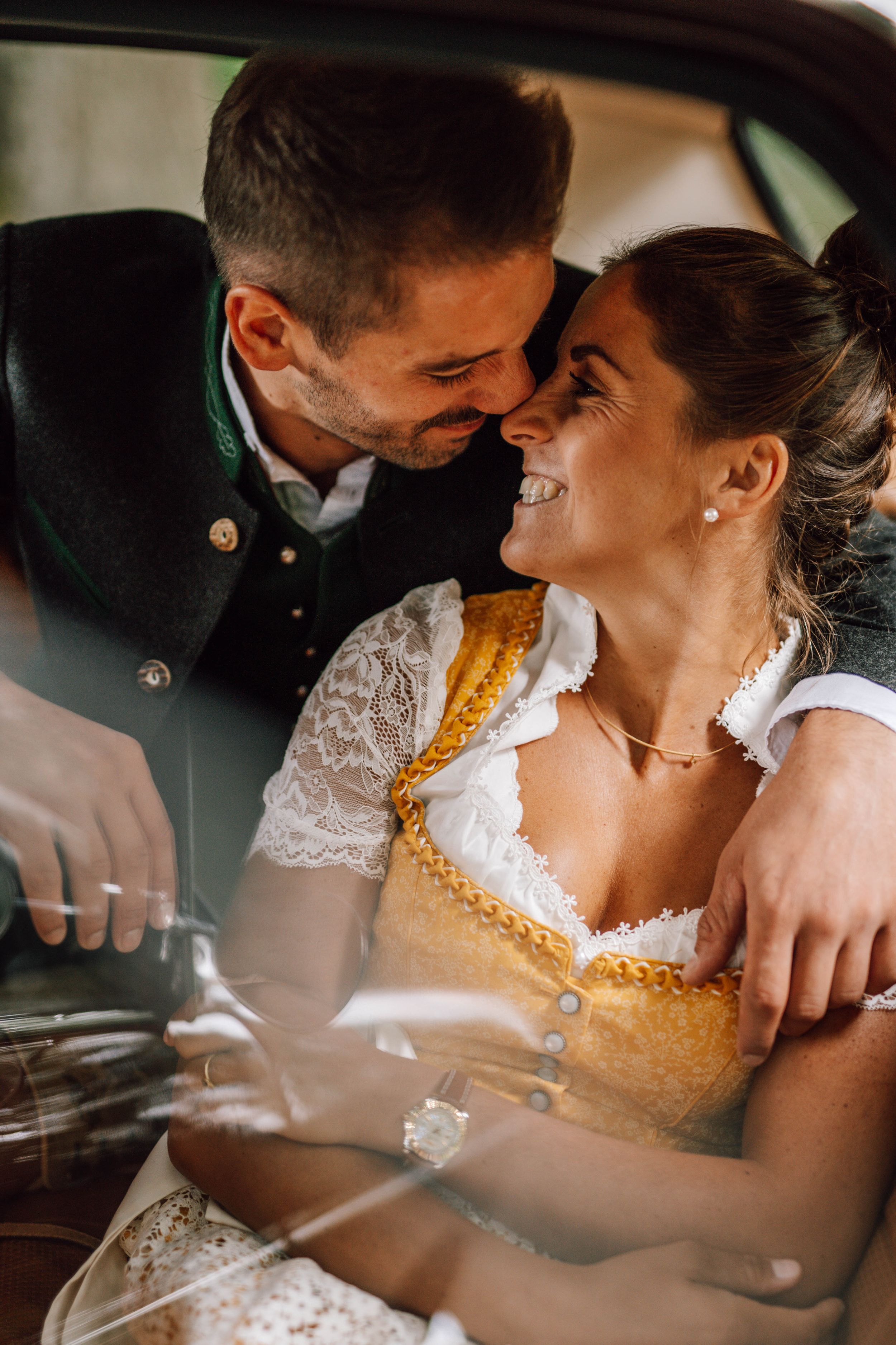 An intimate moment captured between a couple in traditional Bavarian wedding attire.