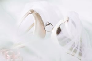 Elegant wedding rings nestled between white fabric in a minimalist styled composition.