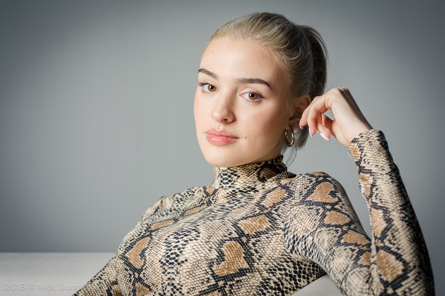 A blond hair girl sitted and looking to us