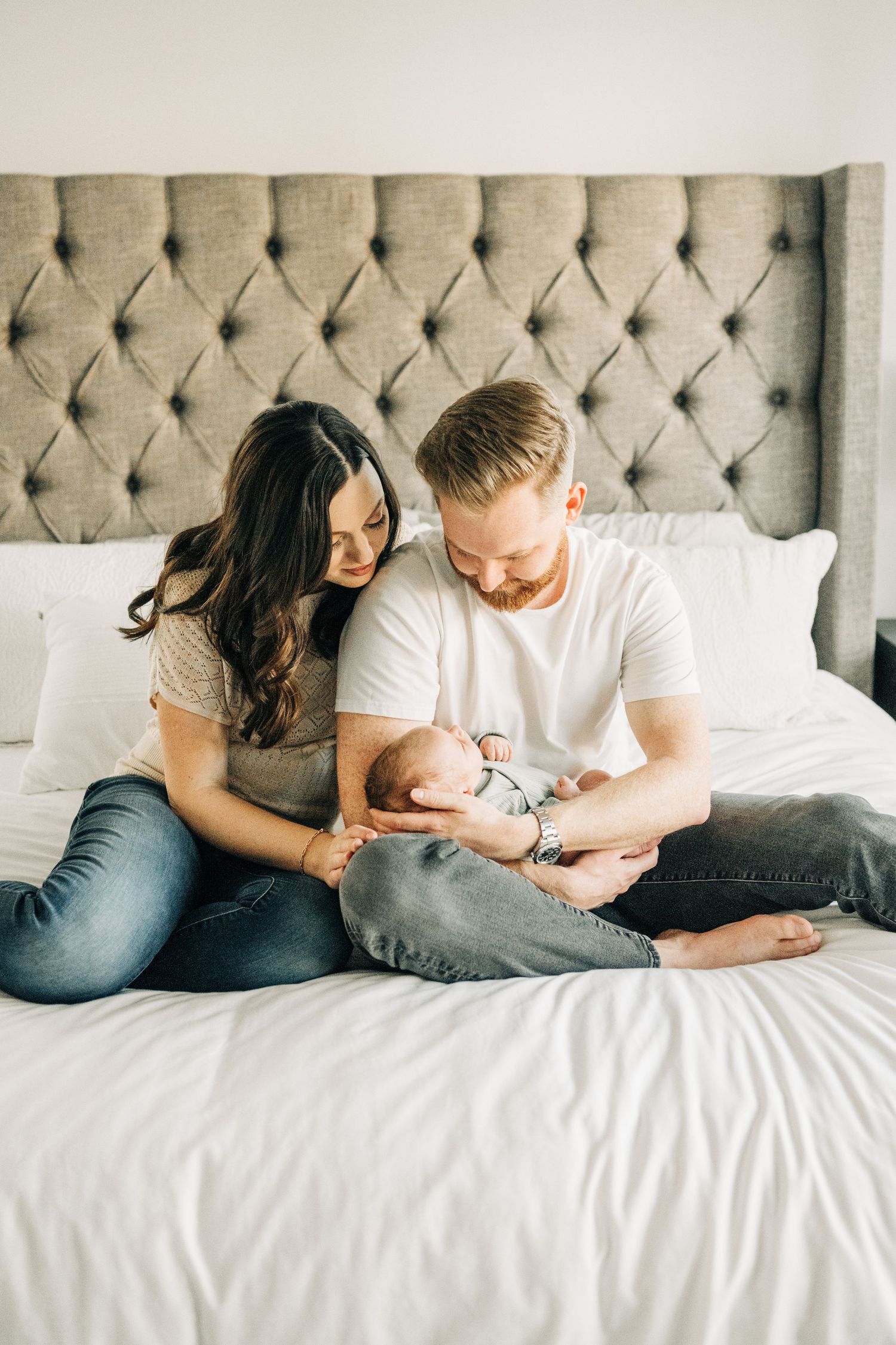 Mom and Dad cuddling newborn during photo session in Frisco, TX