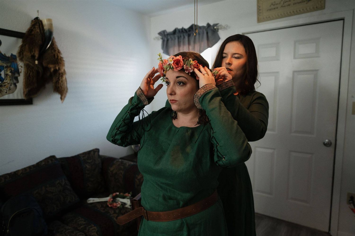Final costume and headdress adjustments being made in a preparation room.